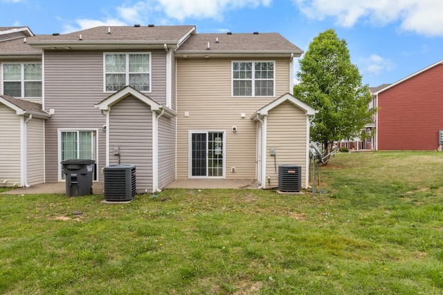 rear view of house featuring a lawn, central AC, and a patio area