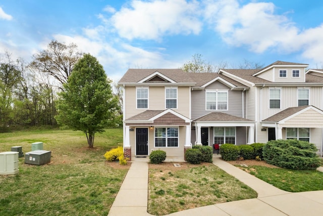 view of property featuring roof with shingles and a front yard