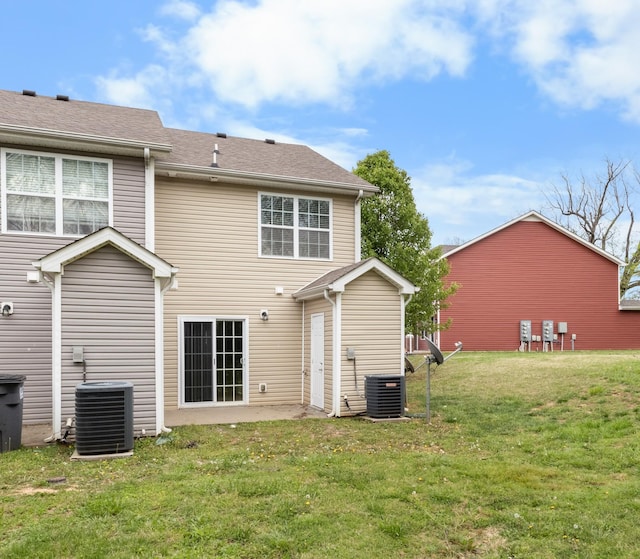 rear view of property with a yard, central AC unit, and a patio area