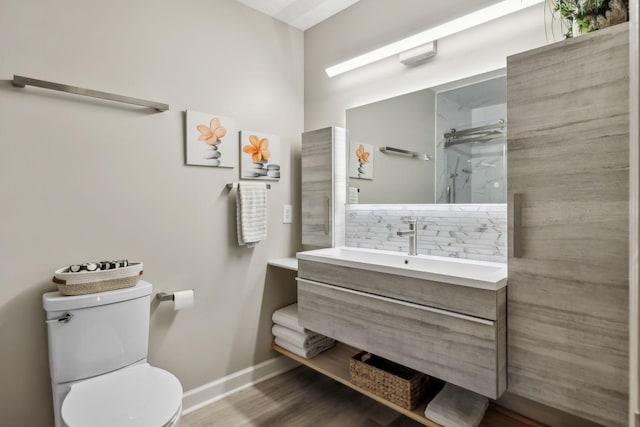 full bath featuring walk in shower, wood finished floors, vanity, baseboards, and toilet