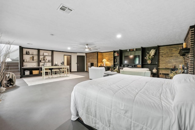 bedroom featuring concrete flooring, wood walls, visible vents, and recessed lighting