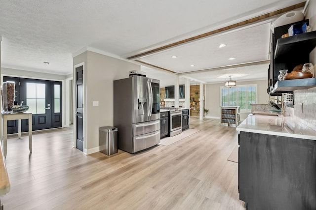 kitchen with crown molding, light stone countertops, light wood-style floors, stainless steel appliances, and baseboards