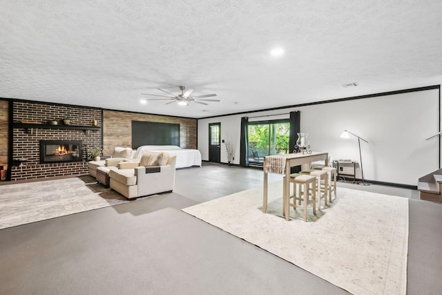living room with a ceiling fan, finished concrete flooring, a brick fireplace, and a textured ceiling