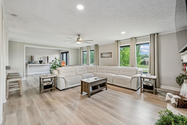 living area featuring recessed lighting, ceiling fan, a wealth of natural light, and light wood-style flooring