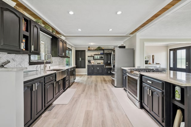 kitchen featuring open shelves, light wood-style flooring, a wealth of natural light, and stainless steel appliances