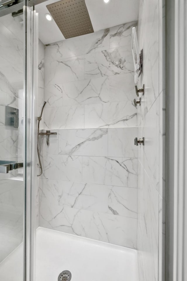 bathroom with a marble finish shower and recessed lighting