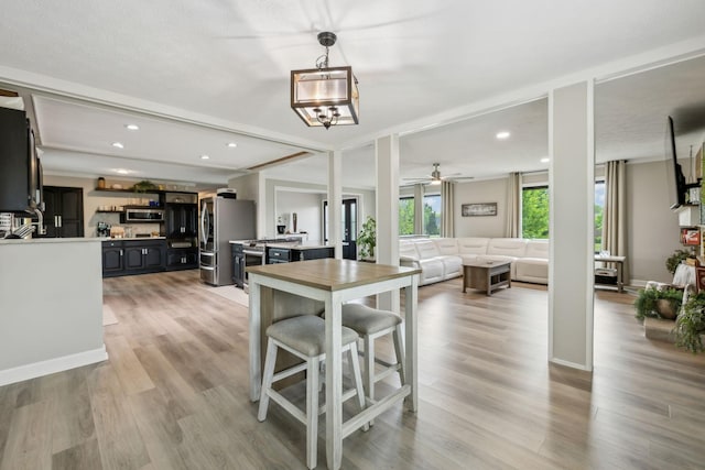 dining area featuring light wood-style floors, a ceiling fan, and recessed lighting