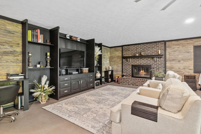 living room with carpet, a textured ceiling, wooden walls, and a fireplace