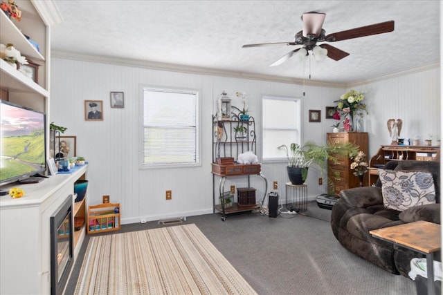 carpeted living room with visible vents, ornamental molding, baseboards, and a ceiling fan