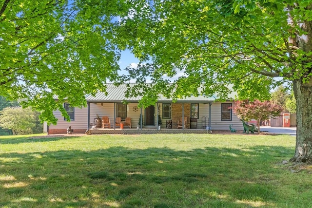 rear view of property featuring a lawn, covered porch, a standing seam roof, and metal roof