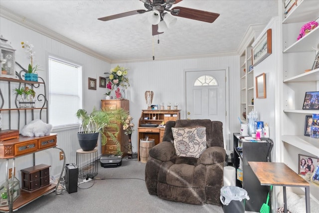 interior space featuring a ceiling fan, a textured ceiling, crown molding, built in shelves, and carpet flooring