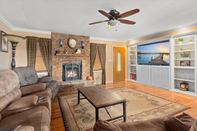 living room with ceiling fan, a stone fireplace, built in features, wood finished floors, and ornamental molding