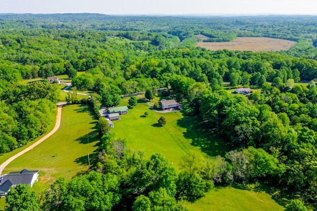 drone / aerial view featuring a wooded view