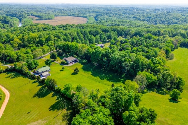drone / aerial view featuring a view of trees and a rural view