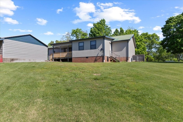 rear view of property featuring a lawn and crawl space