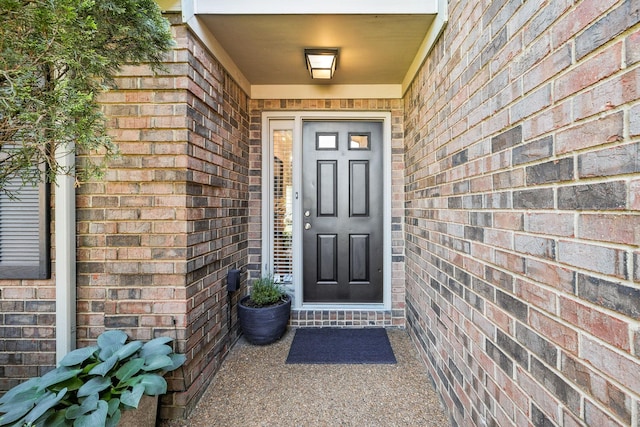doorway to property with brick siding