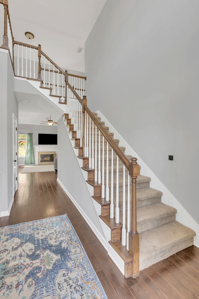 2095 Longhunter Chase Dr, Spring Hill, TN 37174 - stairs featuring a glass covered fireplace, baseboards, and wood-type flooring