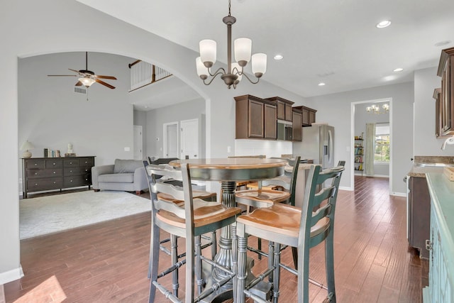 2095 Longhunter Chase Dr, Spring Hill, TN 37174 - dining area featuring dark wood-type flooring, arched walkways, baseboards, and ceiling fan with notable chandelier