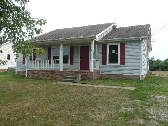 ranch-style home with a porch and a front lawn