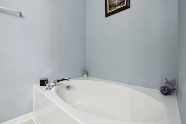 bathroom featuring baseboards and a bath