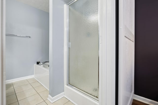 bathroom with an enclosed shower, baseboards, tile patterned flooring, and a bath