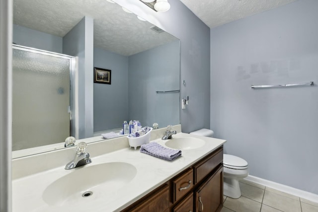 full bath with a sink, a stall shower, toilet, and a textured ceiling