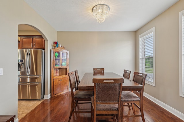 1792 Antler Rd, Woodlawn, TN 37191 - dining room with arched walkways, baseboards, a notable chandelier, and dark wood-style floors
