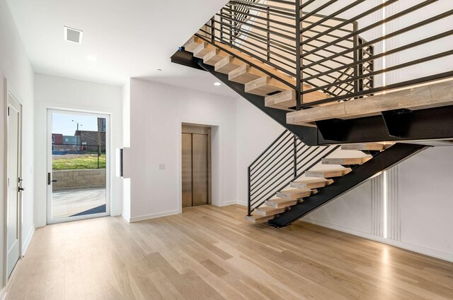 1017 12th Ave S Unit A, Nashville, TN 37203 - staircase featuring baseboards, elevator, visible vents, and wood finished floors