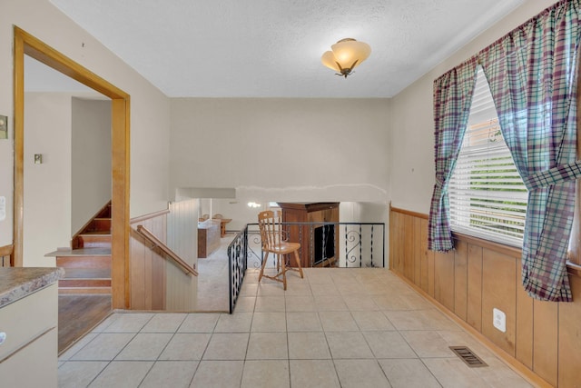 1416 Brannom Dr, Madison, TN 37115 - interior space with a textured ceiling, visible vents, wainscoting, wood walls, and light tile patterned flooring