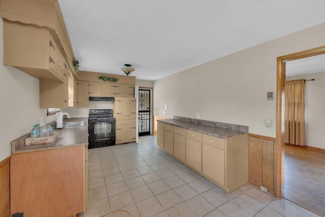 1416 Brannom Dr, Madison, TN 37115 - kitchen with a wainscoted wall, light tile patterned floors, cream cabinetry, black / electric stove, and under cabinet range hood