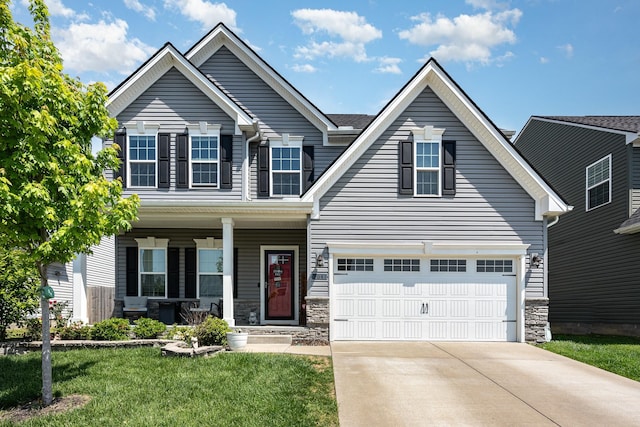 view of front of home with an attached garage, stone siding, a front yard, covered porch, and driveway