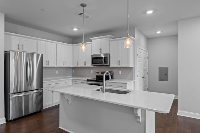 kitchen featuring dark wood-type flooring, a sink, light countertops, and stainless steel appliances