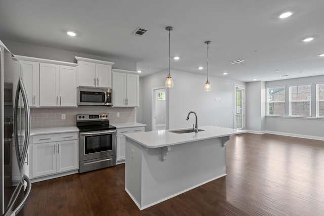 kitchen featuring visible vents, decorative backsplash, light countertops, a sink, and stainless steel appliances
