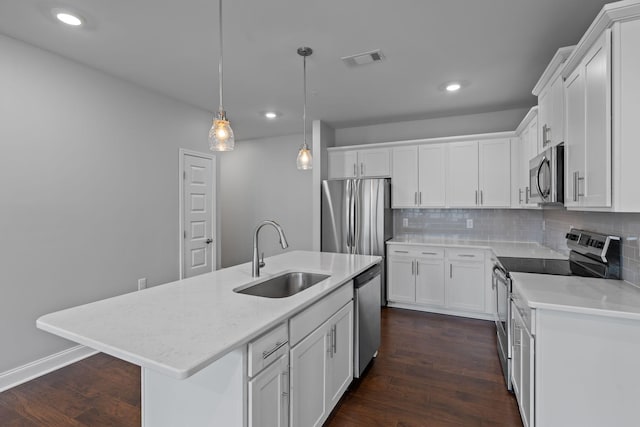 kitchen featuring a sink, stainless steel appliances, tasteful backsplash, visible vents, and dark wood-type flooring