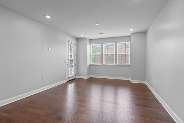 spare room with recessed lighting, baseboards, dark wood finished floors, and visible vents