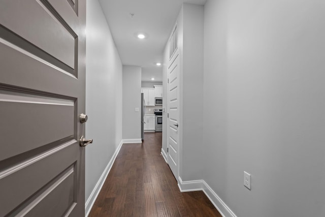 hall featuring baseboards, recessed lighting, and dark wood-type flooring
