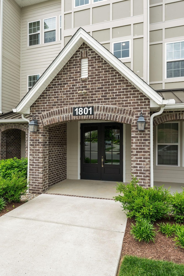 entrance to property featuring brick siding and french doors