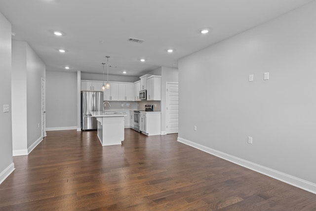 unfurnished living room with visible vents, recessed lighting, and baseboards