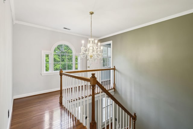 stairs featuring visible vents, baseboards, a notable chandelier, ornamental molding, and hardwood / wood-style floors