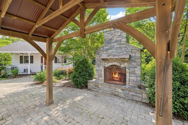view of patio featuring an outdoor stone fireplace and a ceiling fan