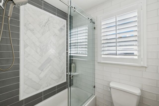 full bathroom with toilet and enclosed tub / shower combo