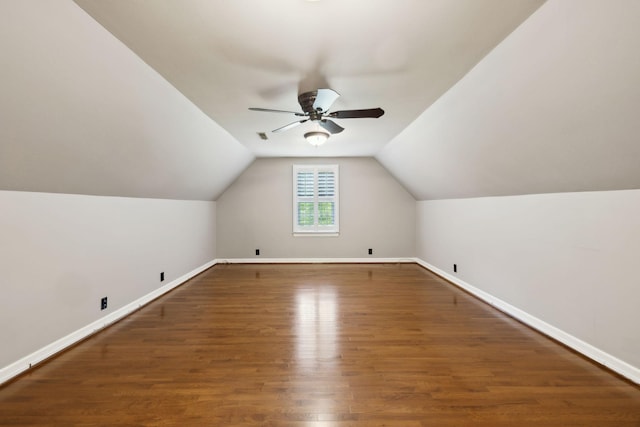 additional living space with baseboards, vaulted ceiling, ceiling fan, and wood finished floors