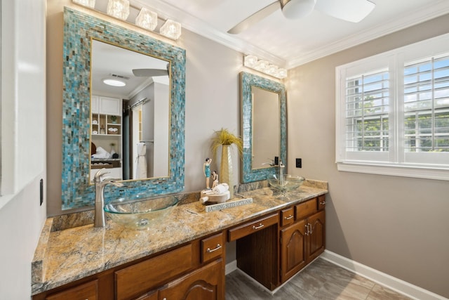 full bathroom featuring crown molding, a sink, double vanity, a ceiling fan, and baseboards