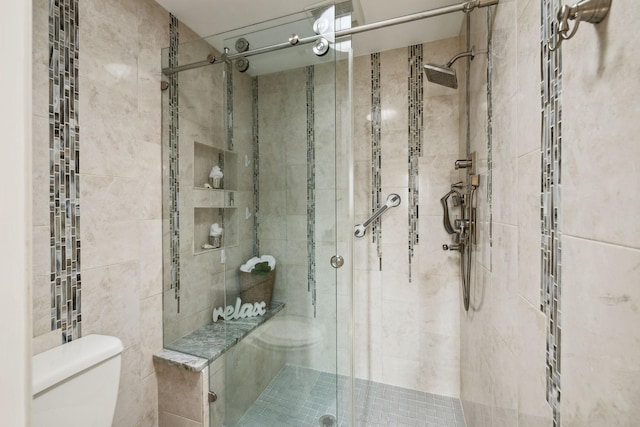 bathroom with a stall shower and toilet