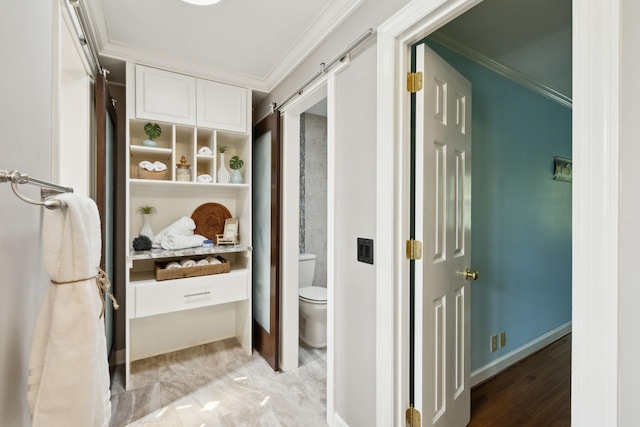 interior space with crown molding, a barn door, and baseboards