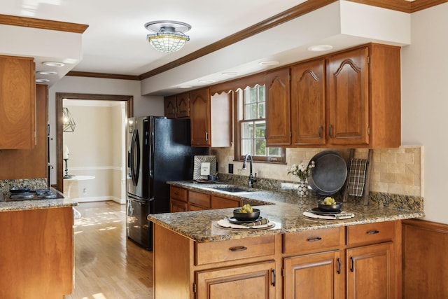 kitchen with backsplash, brown cabinets, and stone countertops