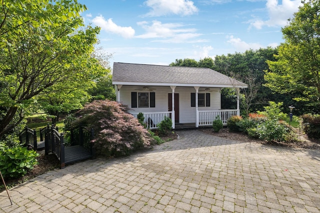 view of front of home with a porch, ceiling fan, and a shingled roof