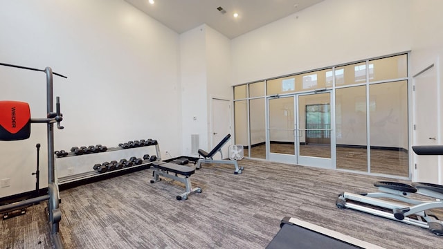 workout room with visible vents, french doors, recessed lighting, and a towering ceiling