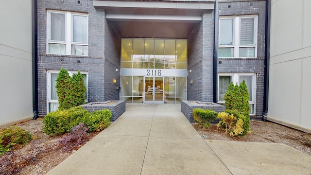 entrance to property featuring brick siding, central air condition unit, and french doors