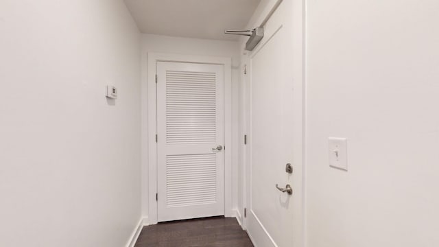 doorway to outside featuring baseboards and dark wood-style floors